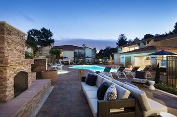 A backyard with a pool and patio furniture